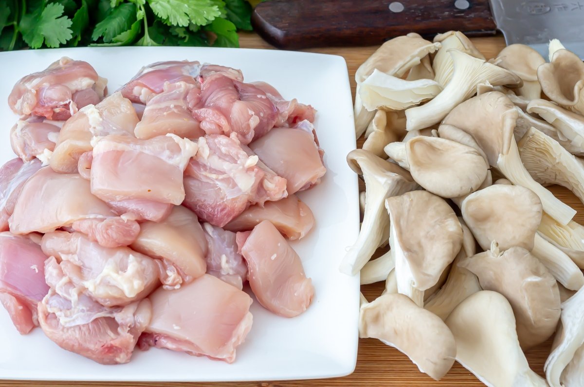 Trocear le pollo y la setas de la sopa tom kha kai