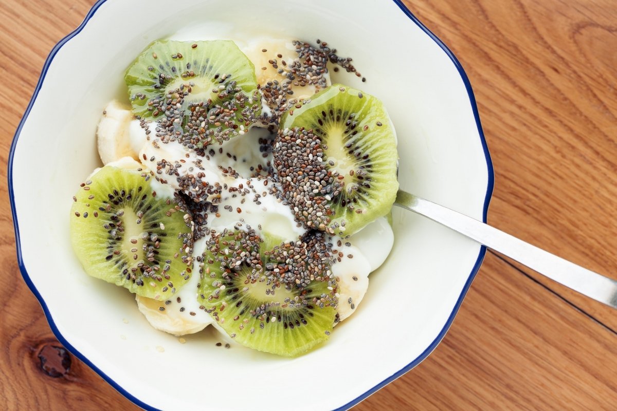 Un bol con yogur con rodajas de kiwi verde y semillas de chía