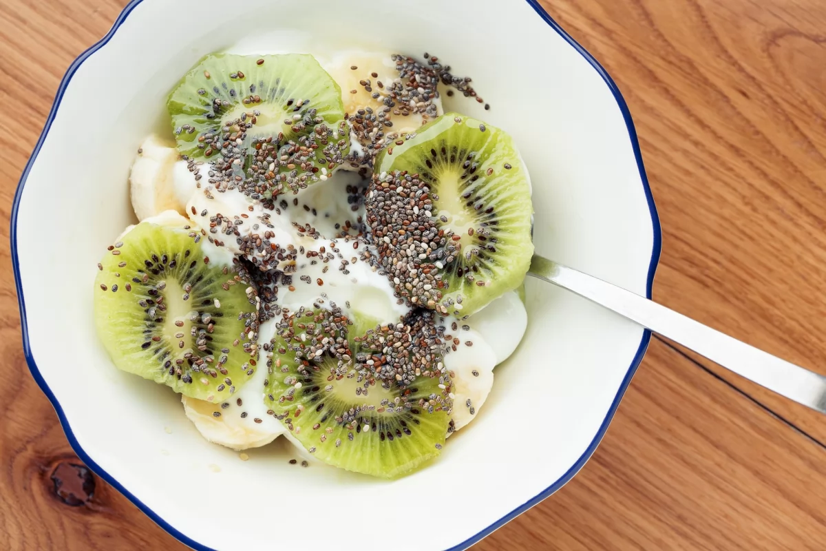 Un bol con yogur con rodajas de kiwi verde y semillas de chía