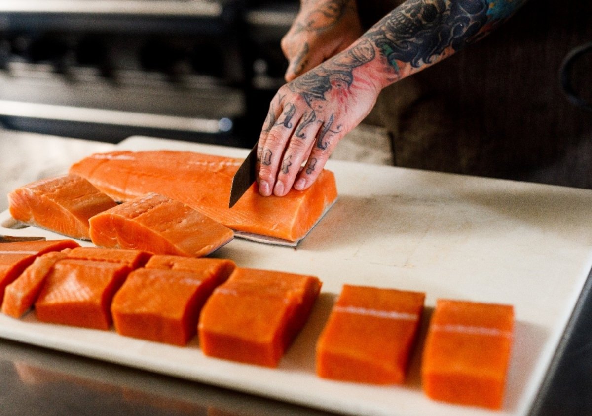 Un cocinero corta diversas piezas de salmón rojo de Alaska