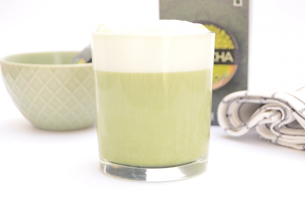 Un vaso con té matcha y espuma de leche