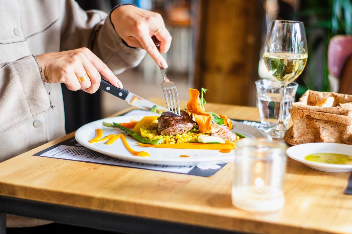Una persona degusta un plato en la mesa de un restaurante