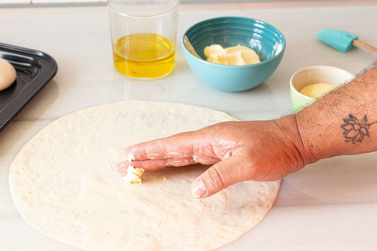 Untamos con mantequilla y espolvoreamos semola