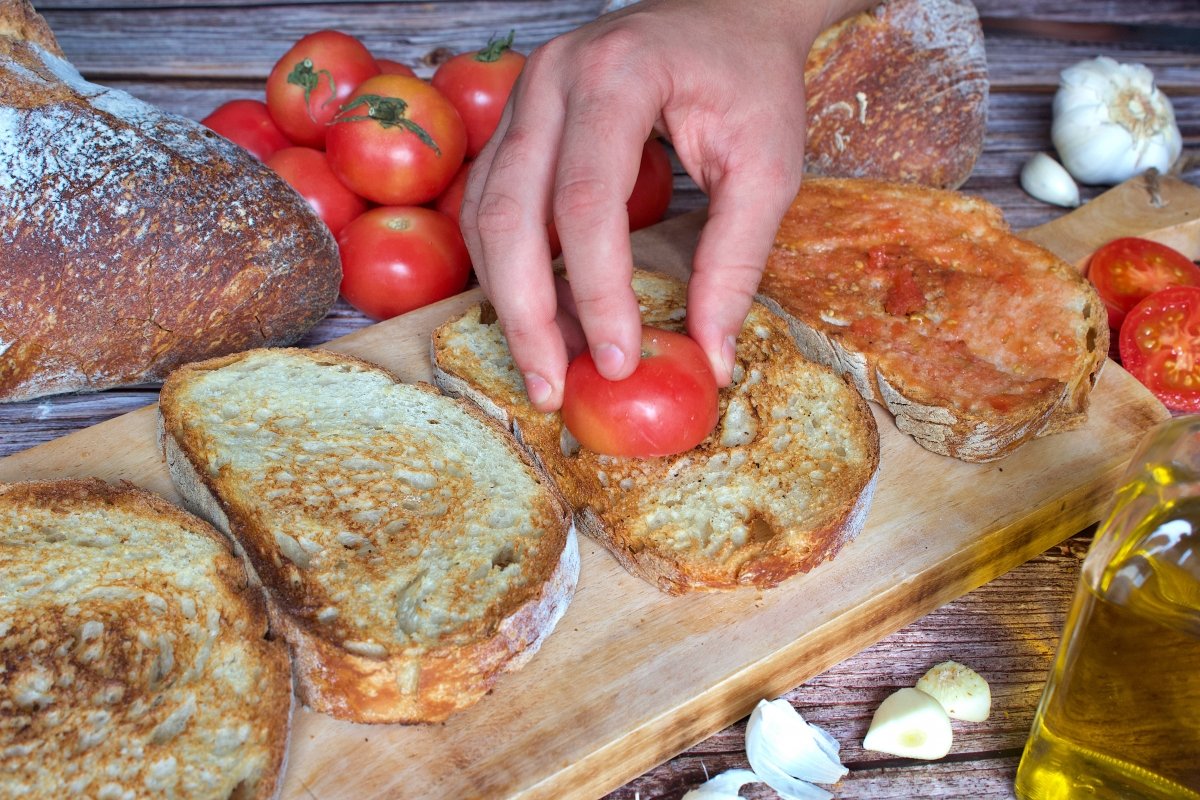 Untando el tomate del pan con tomate (pa amb tomàquet) en el pan