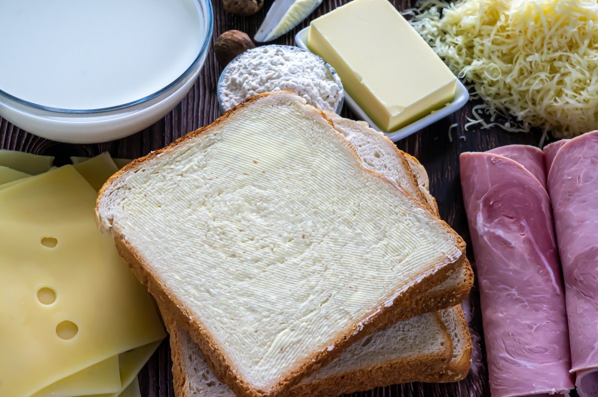 Untar con mantequilla el pan del sándwich croque-monsieur
