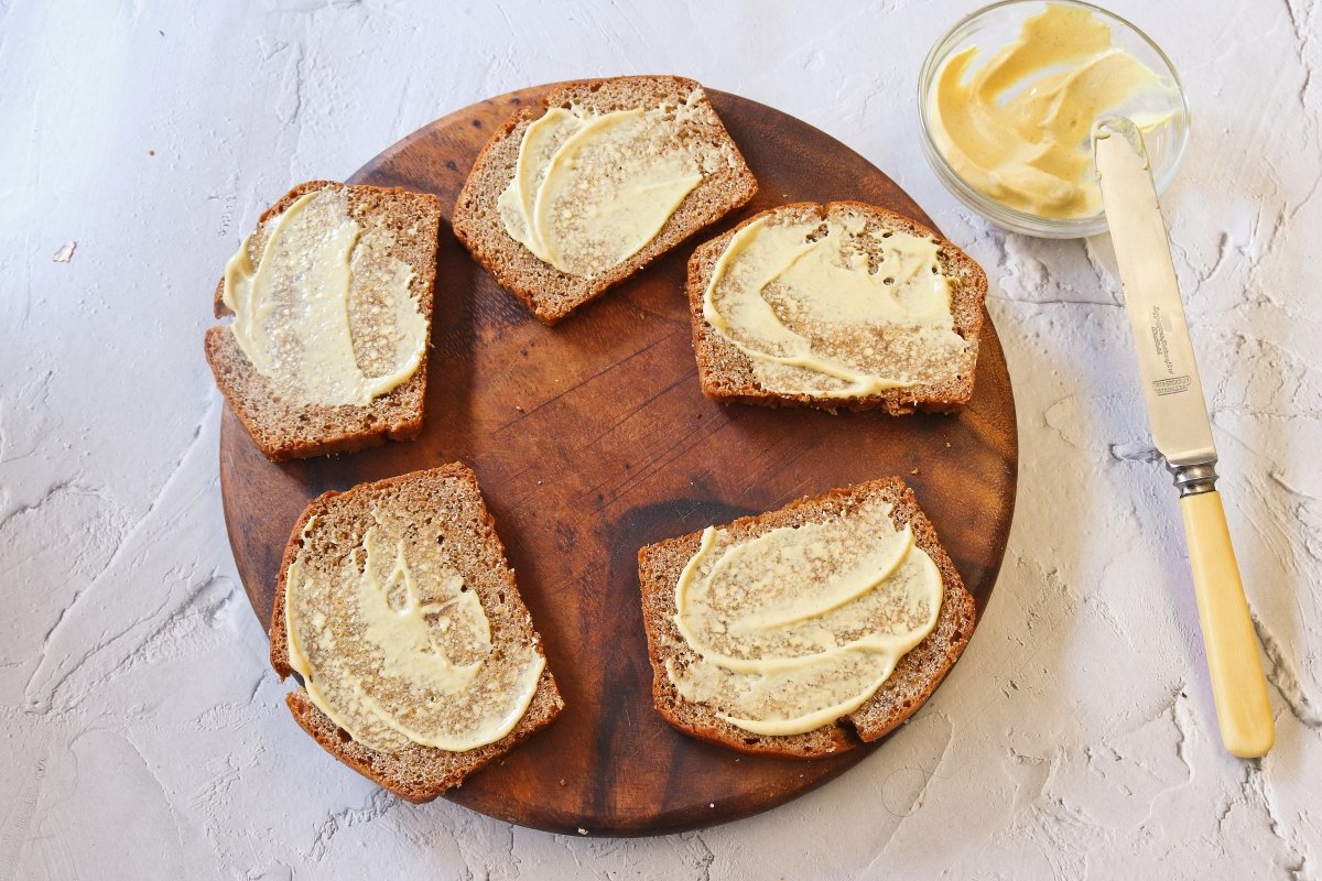Untar el pan de especias con mostaza para la carbonade flamande