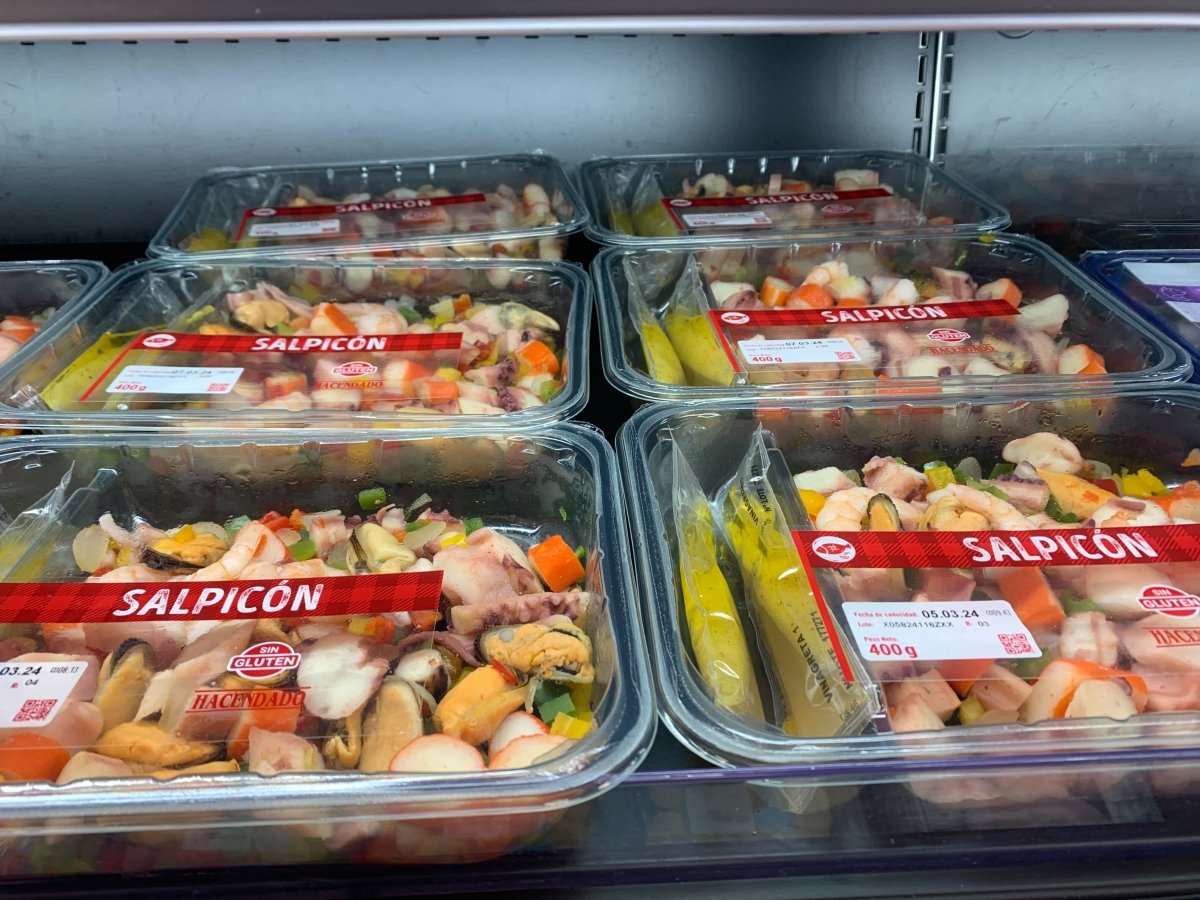 Varios envases de salpicón de marisco de Mercadona en una nevera del supermercado