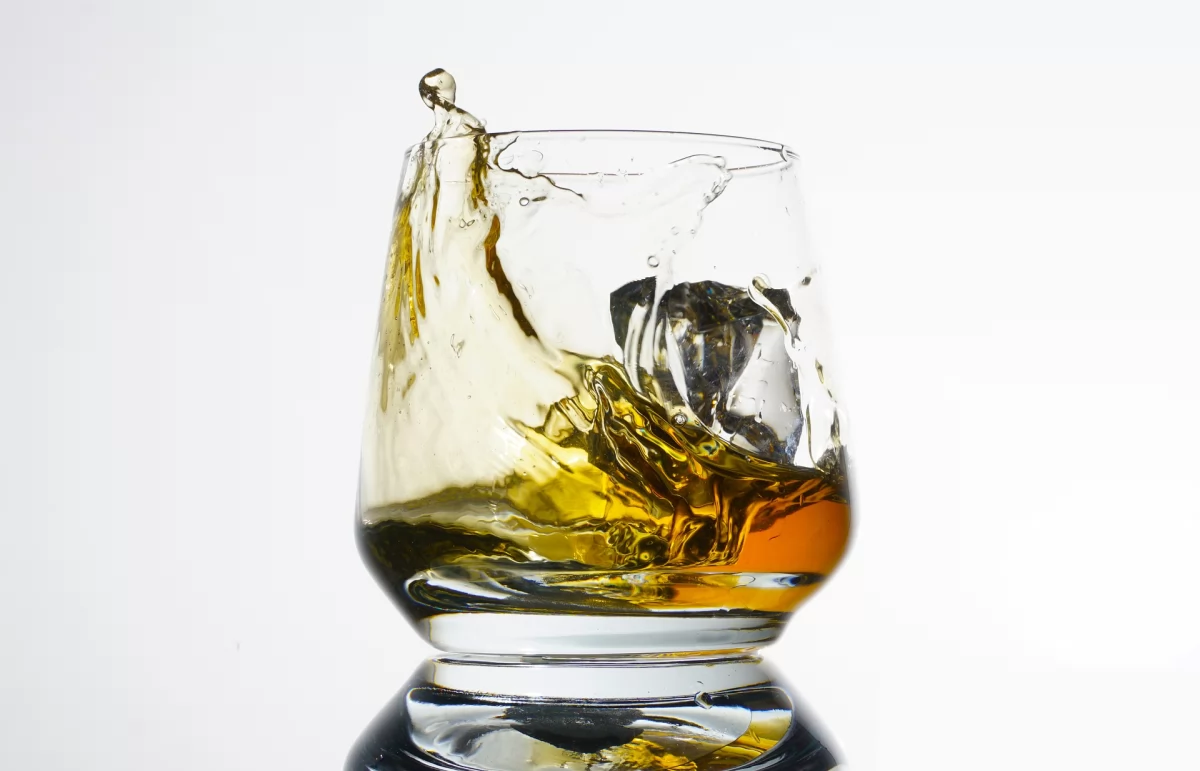 Vaso de cristal con whisky y cubitos de hielo