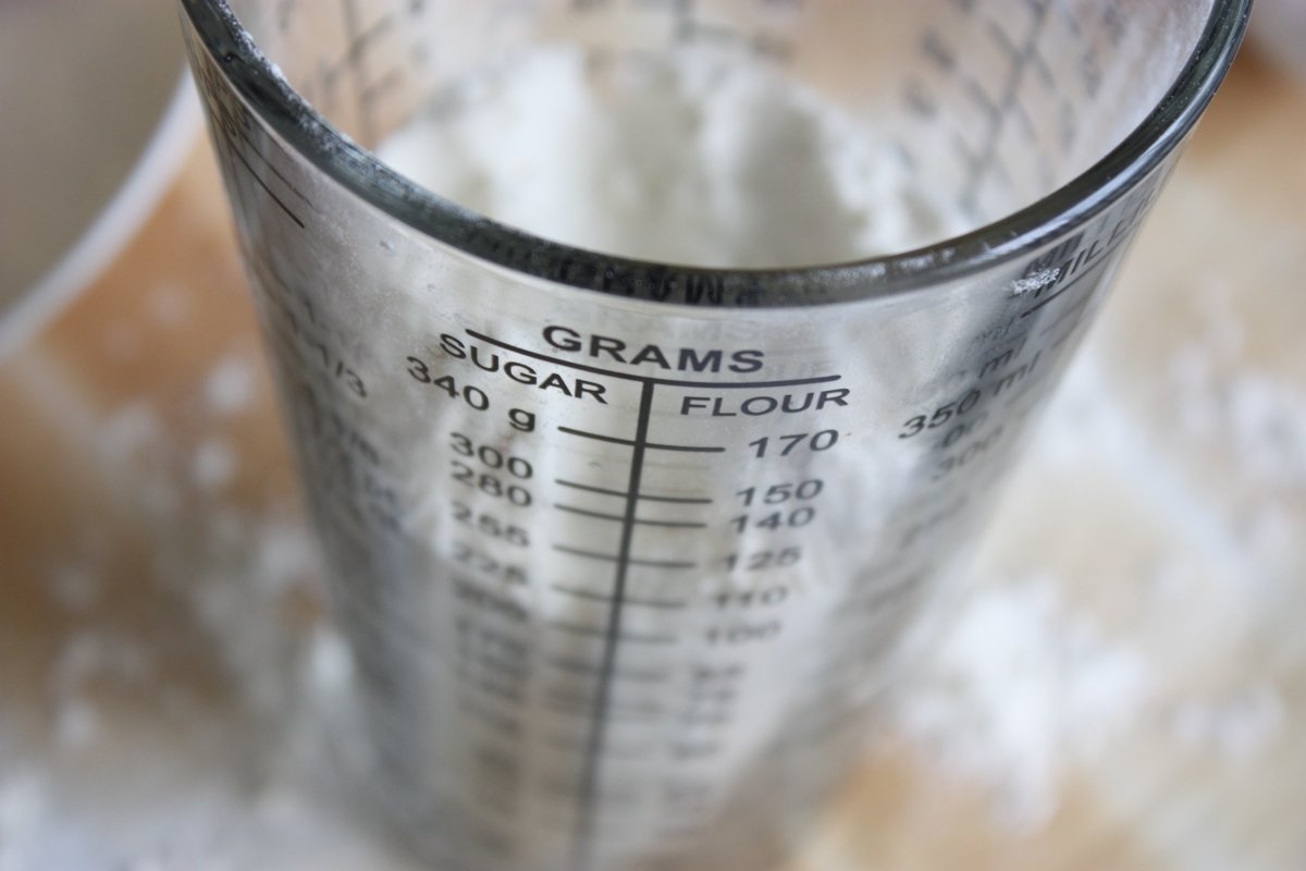 Vaso medidor de cristal lleno de harina para medir los gramos