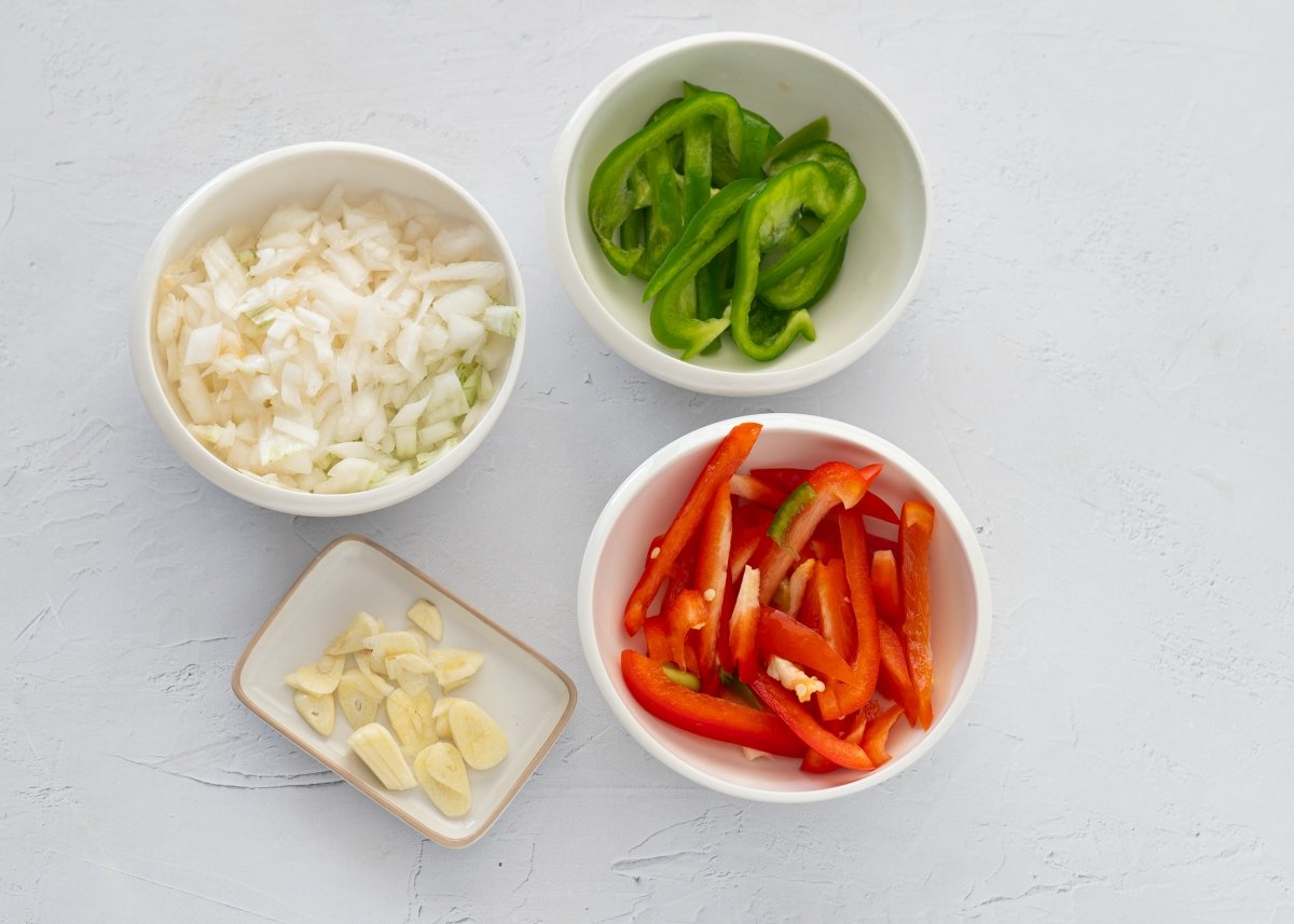 Verduras preparadas para hacer bacalao con tomate y pimientos