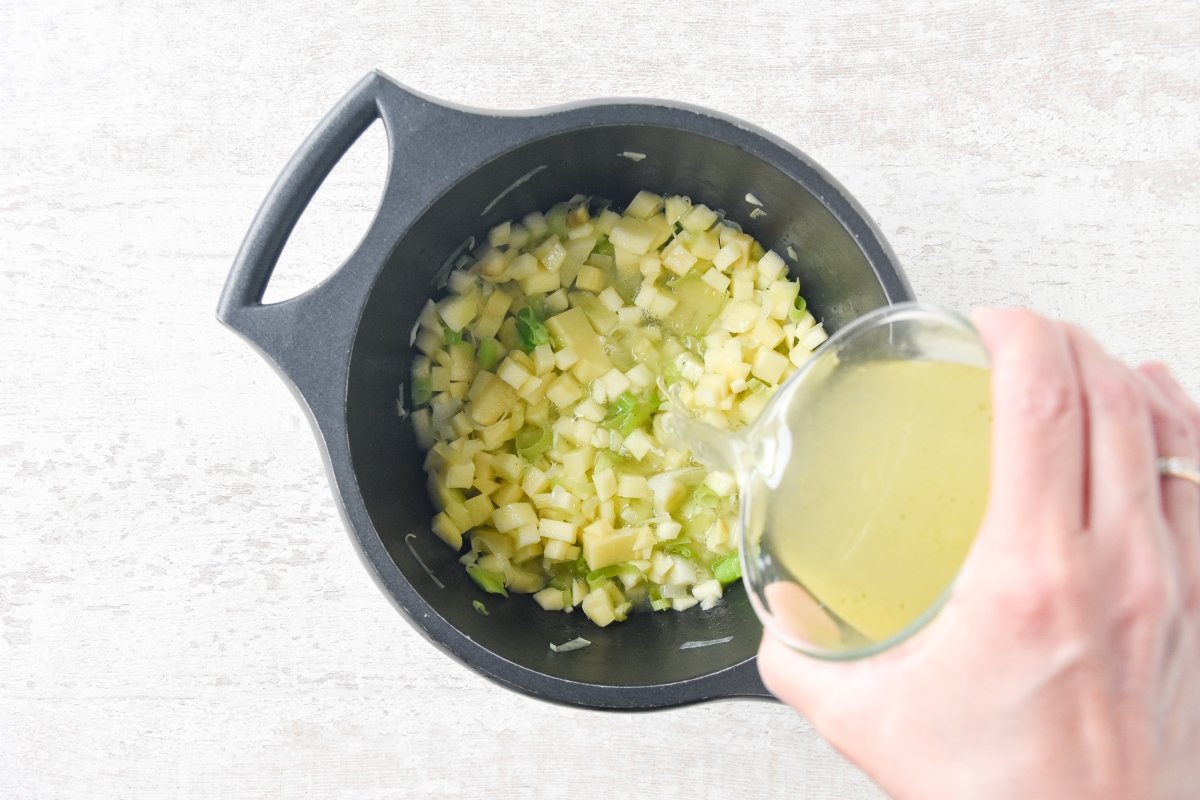 Vertemos el caldo de verduras en la olla con el puerro, la patata y la manzana