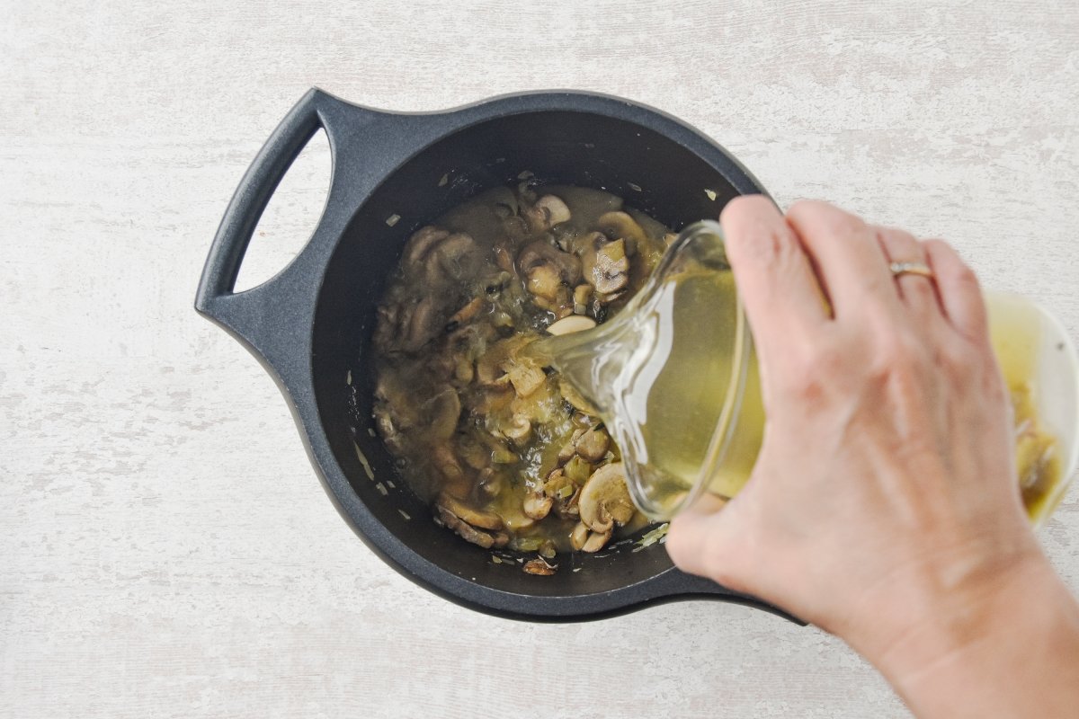 Vertemos el caldo de verduras sobre los champiñones