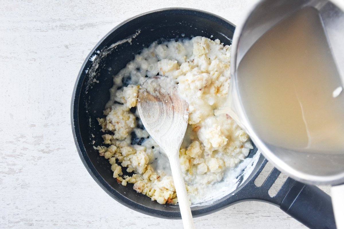 Vertemos el caldo para preparar el roux de las croquetas de pescado