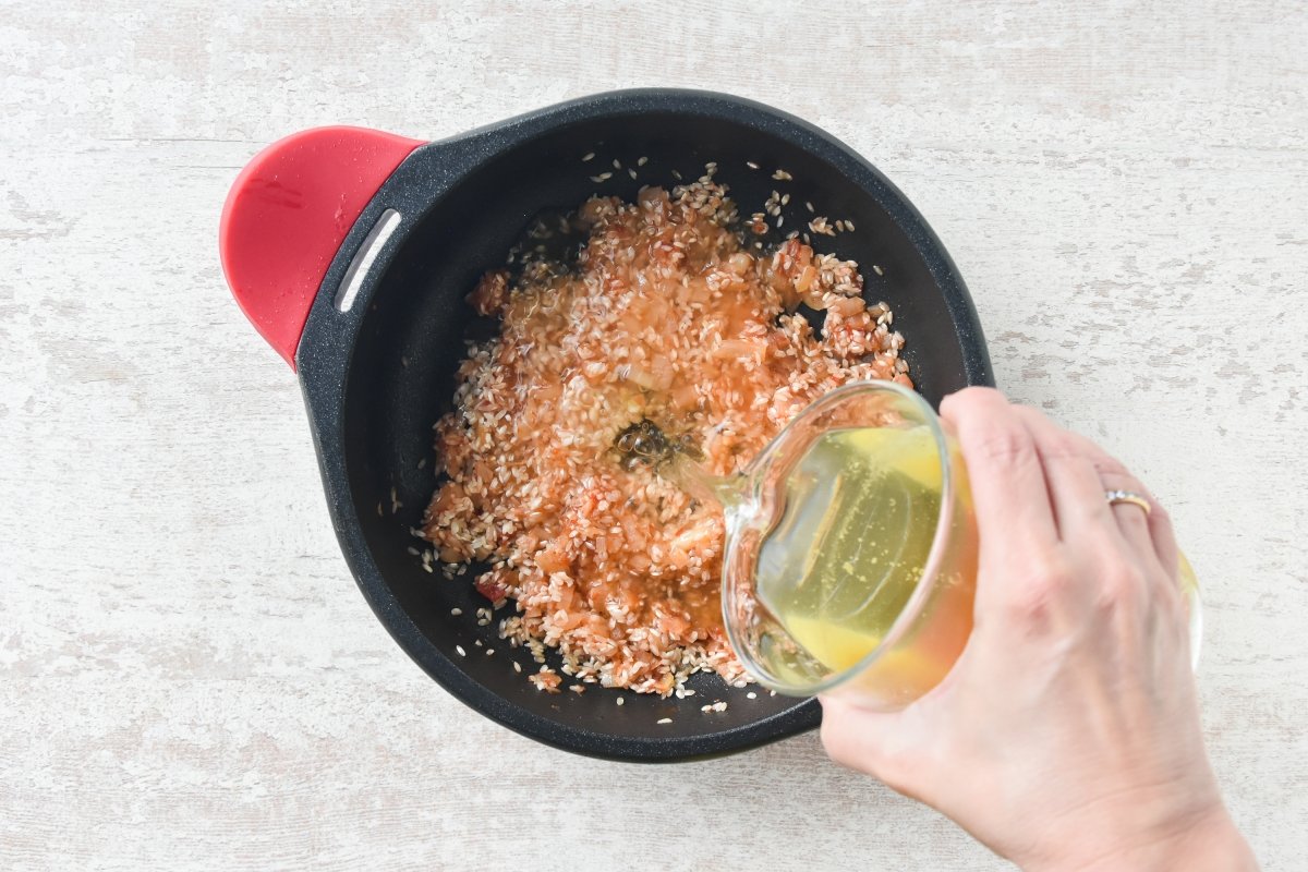 Vertemos el caldo sobre el arroz con el sofrito