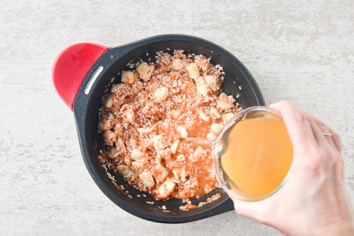 Vertemos el caldo sobre el arroz con sepia