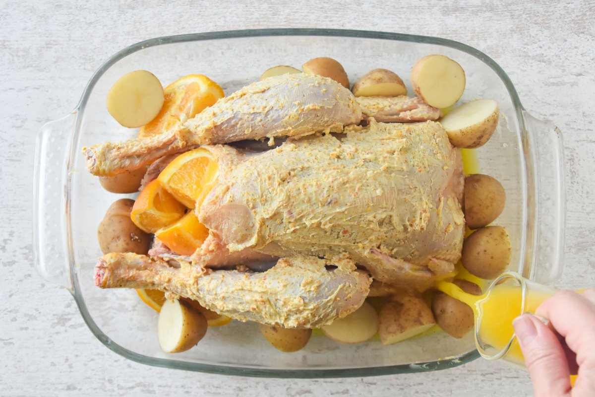 Vertemos el zumo de naranja en la bandeja del pollo