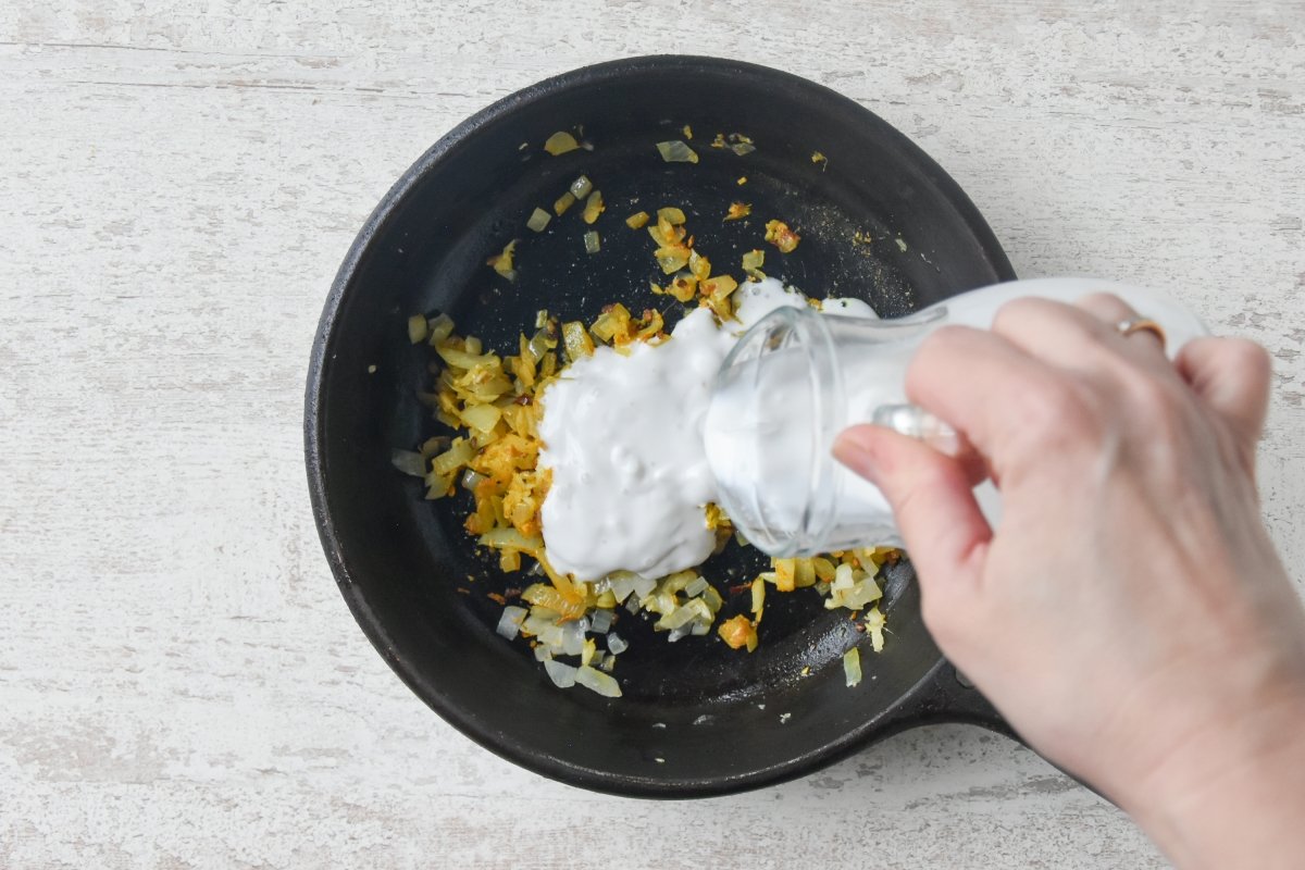 Vertemos la leche de coco para preparar la salsa de curry