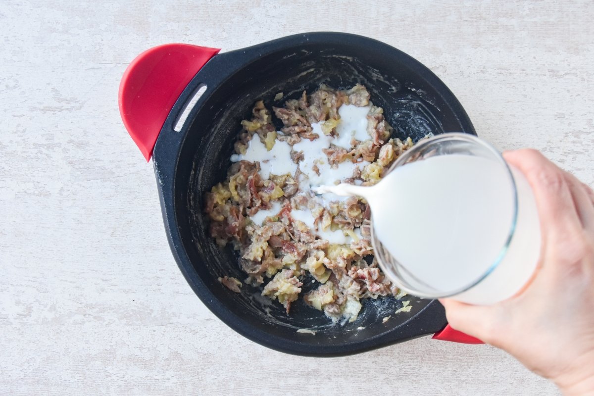 Vertemos la leche fría sobre la cebolla con jamón