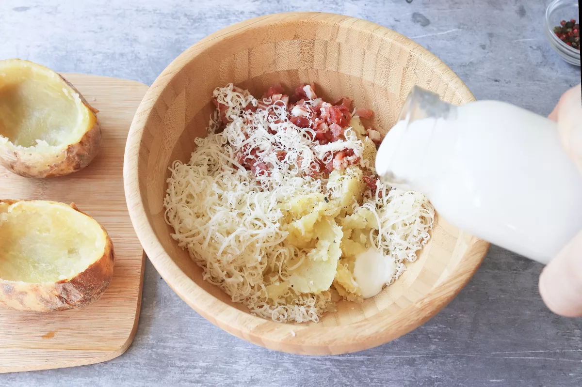 Vertemos la nata patatas rellenas de jamón y queso al horno