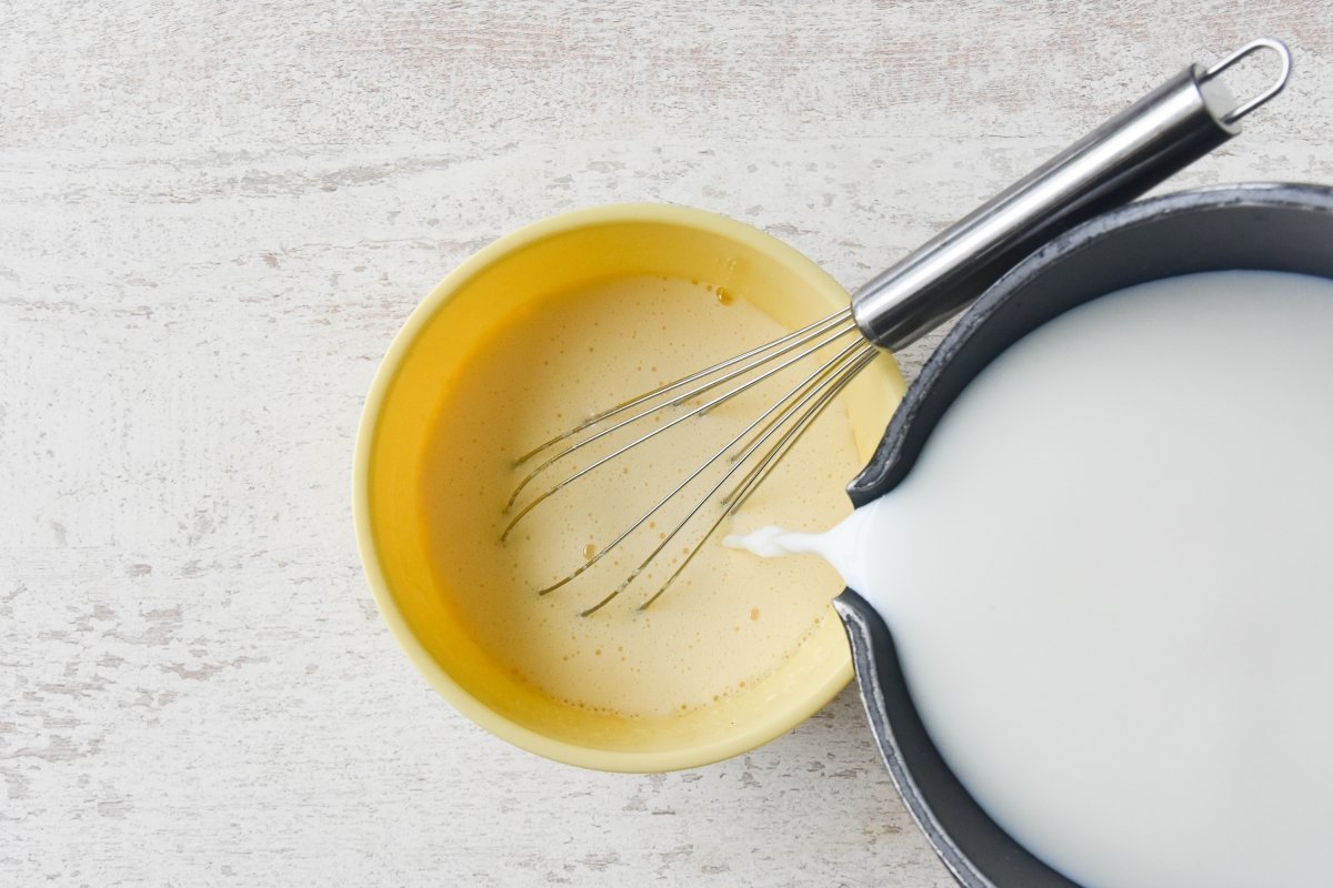 Vertemos un poco de leche caliente sobre las yemas