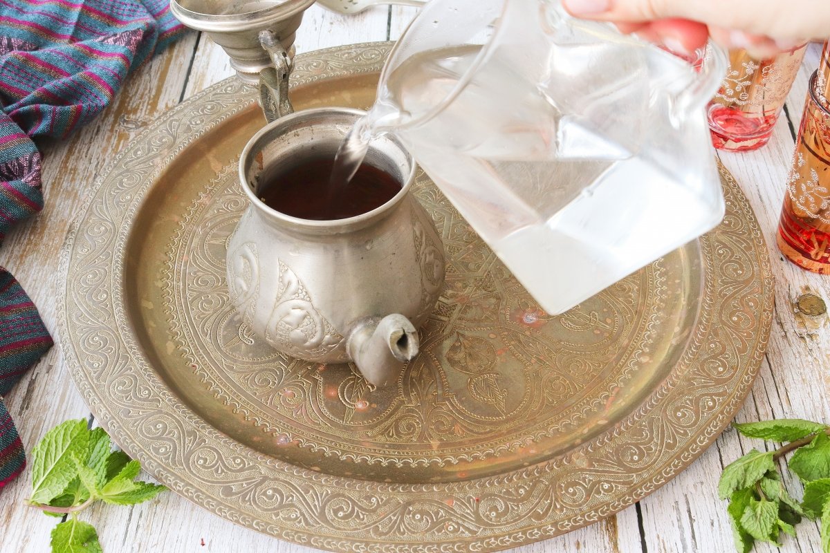 Verter el agua caliente al té marroquí