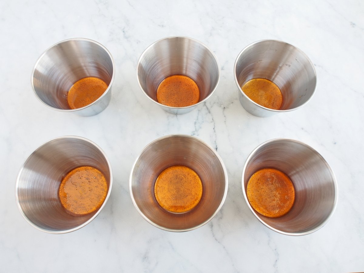 Verter el caramelo en los moldes del flan de naranja