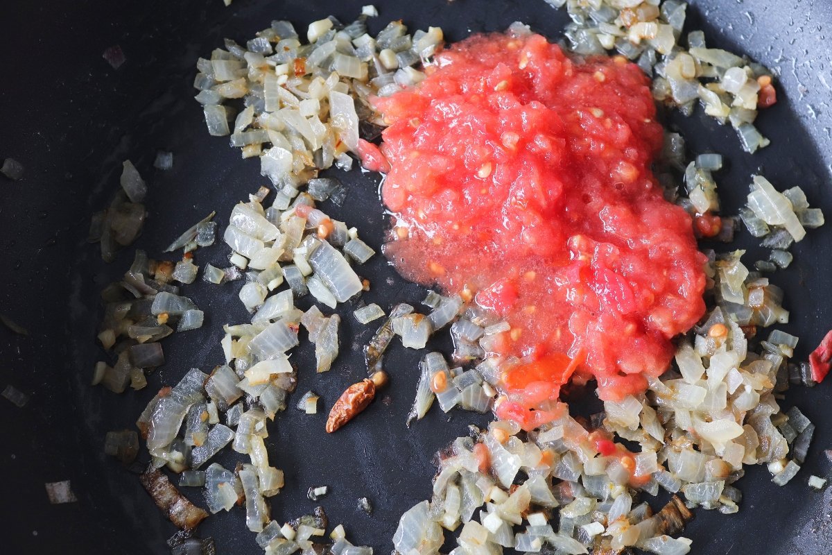 Verter el tomate para la salsa de los gambones en salsa