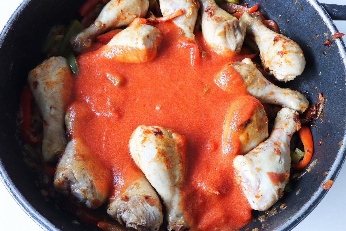 Verter el tomate triturado para el pollo al chilindrón