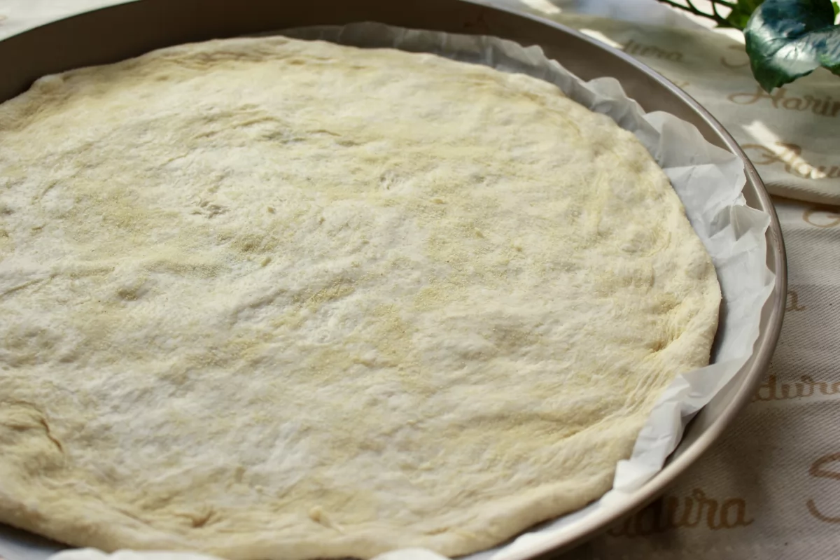 Vista de la masa de pizza extendida sobre la bandeja *