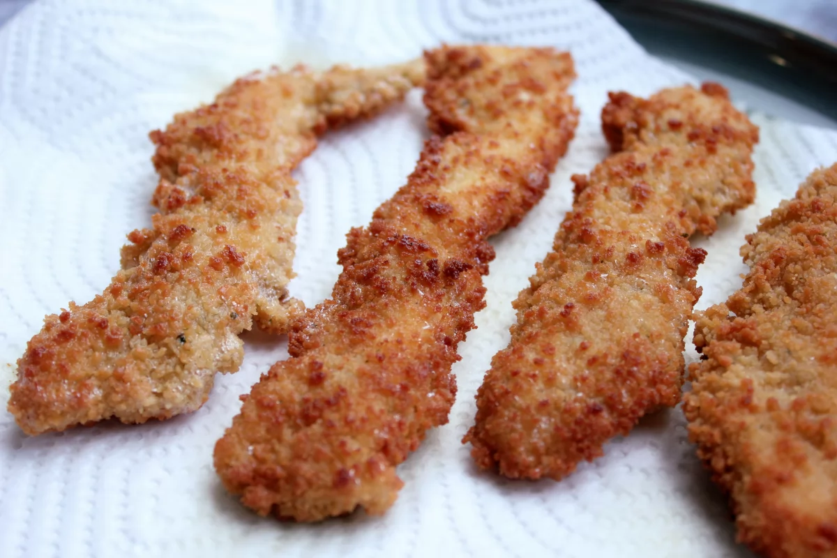 Vista de los fingers de pollo sobre papel de cocina *