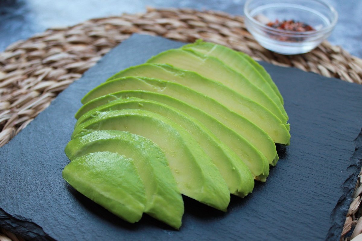 View of half an avocado peeled and cut into slices