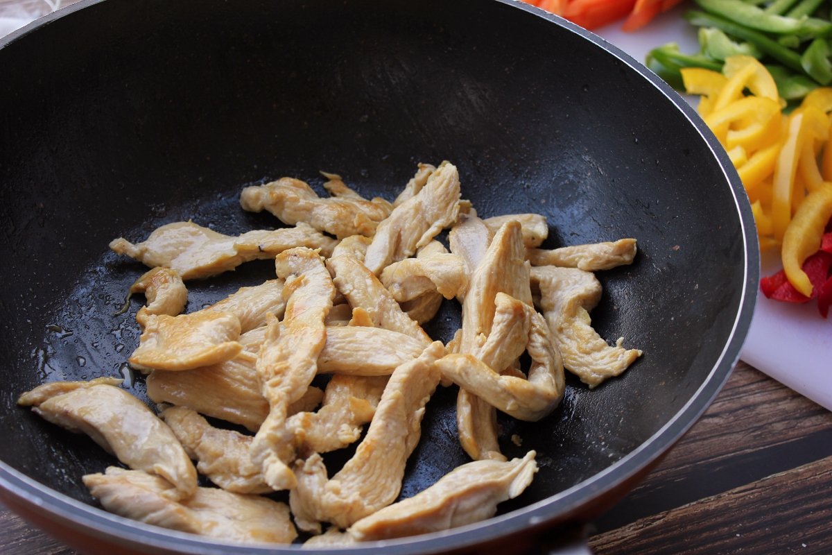 Vista del wok con las tiras de pollo salteadas