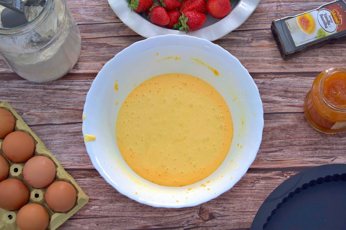 Egg yolks, sugar and starch from the strawberry cake mixed in a bowl